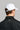 A man wearing a golf cap with ball marker in white