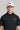 A man wearing a golf cap with ball marker in white