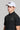 A man wearing a golf cap with ball marker in white