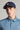 A person wearing a golf cap in navy colour, size fitted