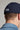 A person wearing a golf cap in navy colour, size fitted