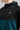 A person wearing a golf hoodie with a 1/4 zip in green and black