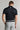 A man wearing a golf polo in black, regular fit