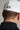 A person wearing a golf cap in white colour, size fitted