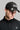 A man wearing a golf cap with ball marker in black