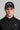 A man wearing a golf cap with ball marker in black