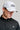 A man wearing a golf cap with ball marker in white