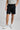 A person wearing golf shorts in black