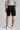 A person wearing golf shorts in black