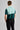 A person wearing a golf polo in green and mint