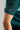 A person wearing a golf polo in green and mint