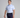 Man wearing a striped polo shirt and navy pants holding a golf club on a gray background
