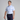 Man wearing a striped polo shirt and navy pants holding a golf club on a gray background