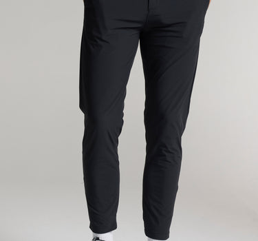 A person wearing black cropped dynamic stretch golf trousers 