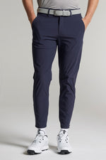 A person wearing navy cropped dynamic stretch golf trousers 
