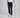 Person wearing navy golf pants and white shoes, holding a golf club on a gray background