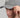 A person wearing a golf cap in grey, size fitted