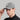 A person wearing a golf cap in grey, size fitted