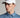 A man wearing a golf cap in white, featuring a ball marker and tonal logo