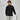 Man in black quarter-zip sweatshirt and light gray pants holding a golf club on a white background