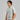 Man wearing a gray polo shirt with a logo on a gray background