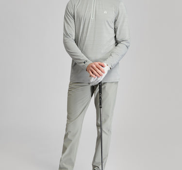 A person wearing a zip top in grey