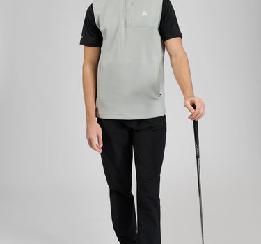 A man wearing a golf vest in grey