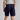 Person wearing navy shorts on a plain background