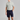 Man wearing a light gray polo shirt and navy shorts on a gray background