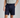 Person wearing navy shorts and a light gray shirt on a plain background