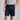 Person wearing navy shorts and a light gray shirt on a plain background