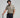 Man in golf attire holding a golf club against a plain background