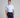 Man wearing a light blue patterned shirt and dark blue pants on a gray background