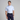 Man wearing a light blue patterned shirt and dark blue pants on a gray background