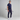 Man wearing a navy golf outfit holding a golf club on a gray background