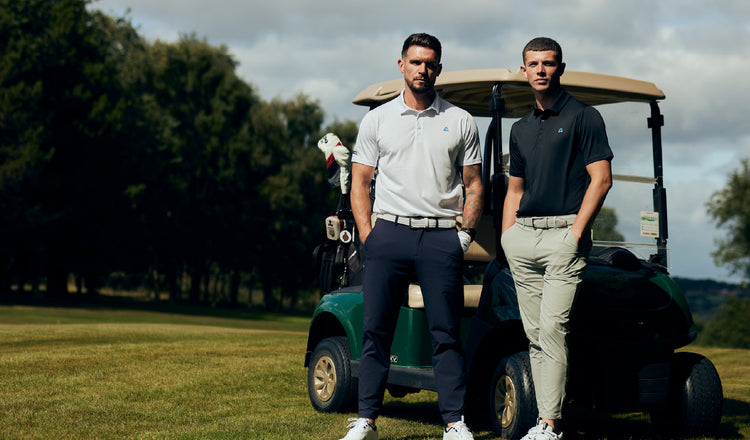 Two men wearing golf polo standing next to a golf cart