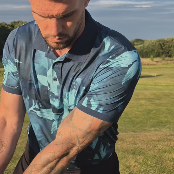 Video of male golfer in a blue floral polo shirt